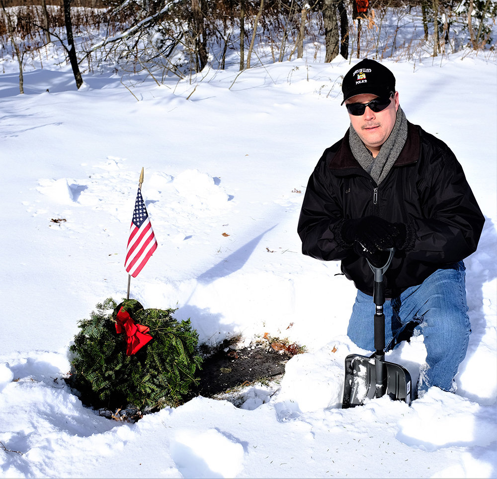 Lloyd Police Chief James Janso cleared away the snow and laid a wreath on the grave of Sgt. Herbert B. Johnson, who was killed in Vietnam in 1968.